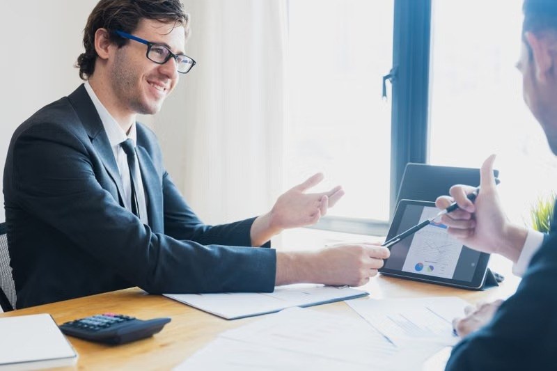 Smiling advisor explaining a financial report to a client